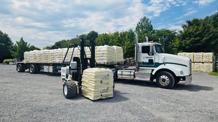 forklift unloading a wood pellet truckload
